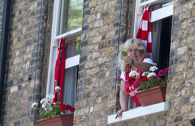 football: An Arsenal fan leans out of a window
