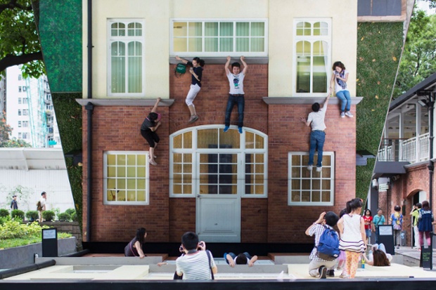 Hong Kong, China: Visitors are reflected in a mirror while sitting on Leandro Erlich's installation, titled Batiment - Oi!