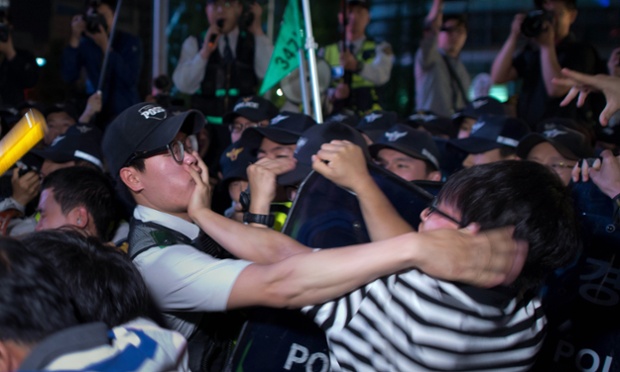 Seoul, South Korea: Protestors and police clash during a a candle-lit rally following a vigil for victims of the Sewol ferry disaster.