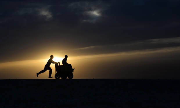 Mazar-e-Sharif, Afghanistan: Boys playwith an ice cream cart at sunset.