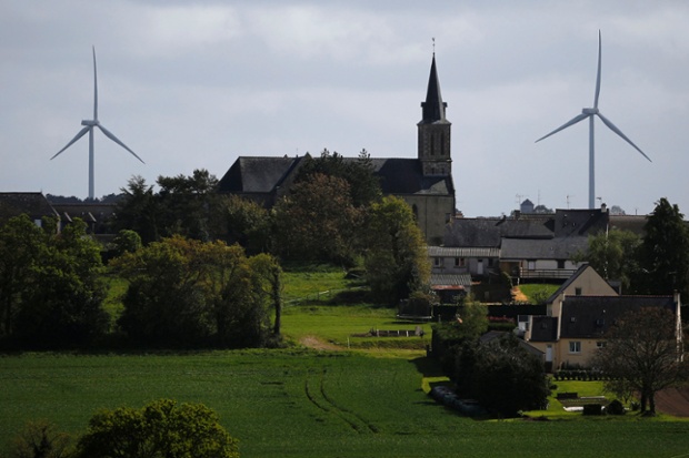 Wind turbines are seen in the Landes de Couesme wind farm near La Gacilly seen near the church in Saint-Nicolas-du-Tertre, western France, April 26, 2014.