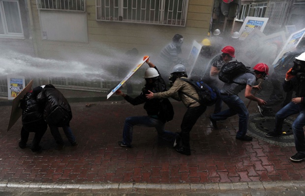 Protesters shield themselves as riot police use water cannon to disperse them during a May Day demonstration in Istanbul.