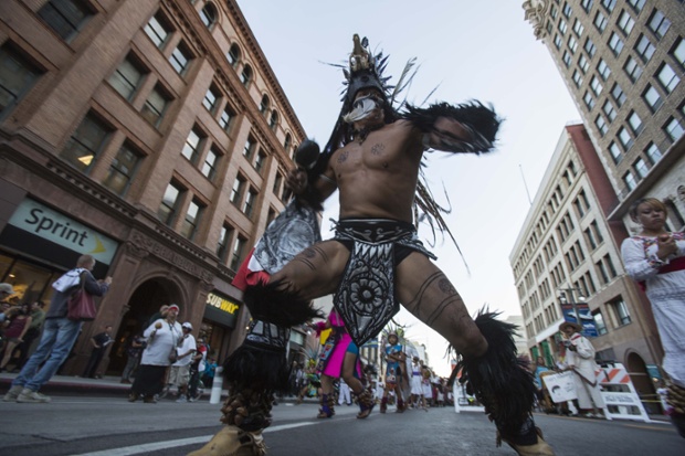 Mexican indigenous people dance as they thousands of people participating in the annual May Day marches downtown Los Angeles.