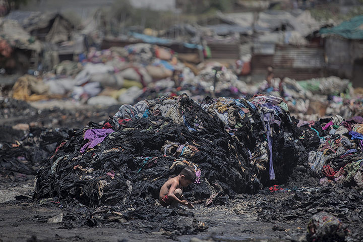 20 Photos: An Indian boy looks for metal scrap after a fire at a slum in Ghaziabad