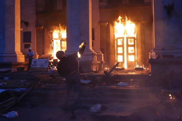 A protester throws a petrol bomb at the trade union building in the centre of Ukraine's southern port of Odessa. At least 38 people have been reported to have been killed in the fire.