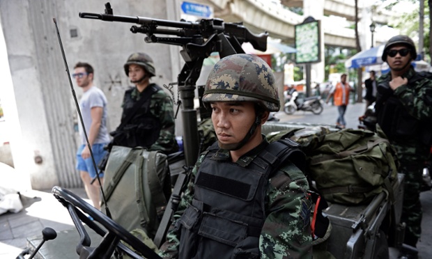 Thai army soldiers sit in a jeep mounted with a machine gun after martial law was declared across the country. Follow the latest events in Thailand in our live blog.