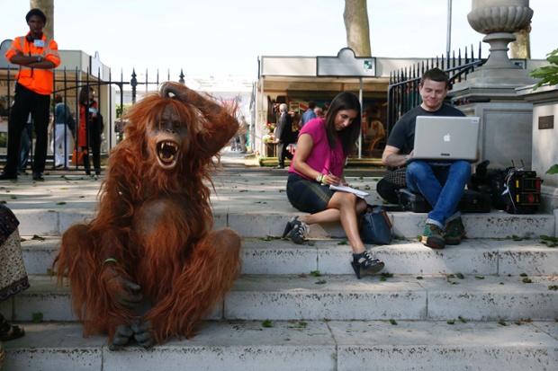 Double take: a man dressed as an orangutan sits next to members of the press during media day at the Chelsea Flower Show in London.