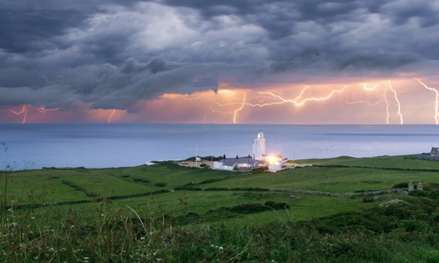 Lightning over St Catherines Lighthouse, Niton on the Isle of Wight. The dramatic weather conditions formed as warm air clashed with a cold front moving in over the country afterthe hottest day of the year so far yesterday.