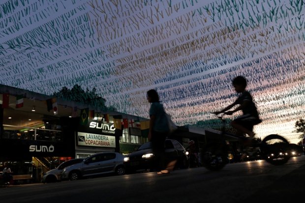 Silhouetted mother and her son cross a street decorated for the upcoming World Cup in Brasilia, Brazil.