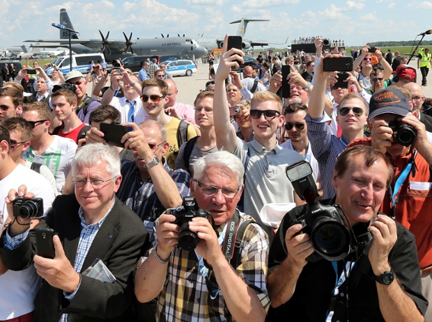 Visitors try to get a glimpse (and a snap) of German Chancellor Angela Merkel at the opening of the Show.
