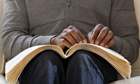 A man reading a braille book