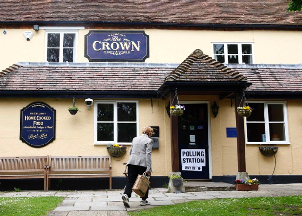 A voter walks into The Crown public house, which is being used as a polling station in South Moreton.