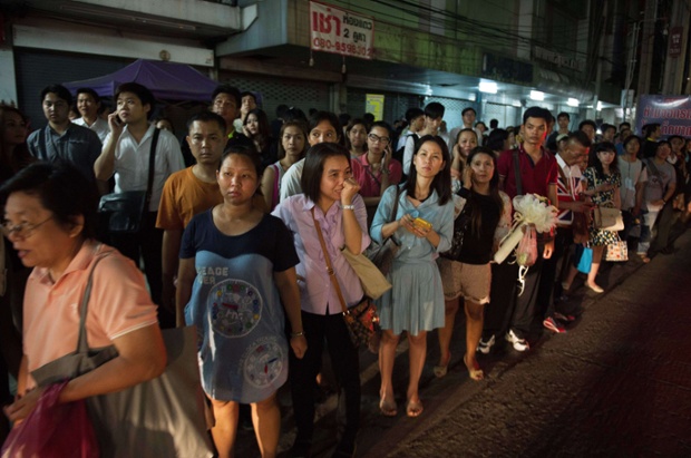 Thai commuters wait for taxis as they try to beat the curfew imposed following the Thai army chief's announcement that armed forces were seizing power in Bangkok.