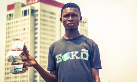 A young man sells Plantain Chips in traffic jam at Marina Lagos.