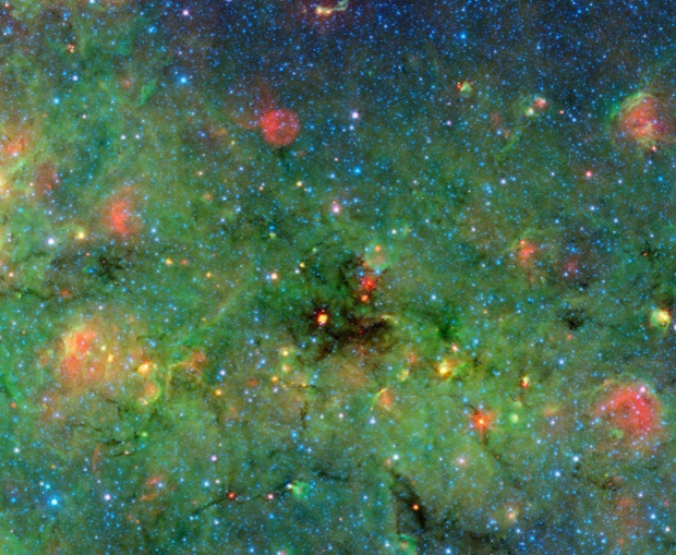 NASA image shows clumps that were discovered within a huge cosmic cloud of gas and dust. Infrared observations from NASA's Spitzer Space Telescope of these blackest-of-black regions in the cloud paradoxically light the way to understanding how the brightest stars form.The large cloud looms in the center of this image of the galactic plane from Spitzer. The zoom shows details of the cloud, revealing the dense clumps.