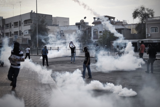 Protesters run for cover from tear gas fired by riot police during clashes after the funeral of Sayed Mahmood Sayed Mohsin in Sitra, Bahrain. Mohsin, 15, was shot dead by security forces during an opposition protest.