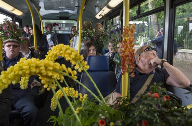 Gardening enthusiasts board a bus with flowers purchased on the final day of the Chelsea Flower Show in London.