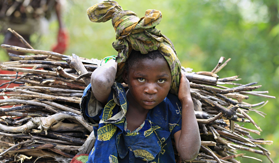 A Congolese girl carries firewood, collected from a forest, in Bunagana town