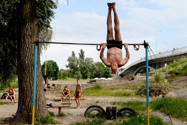 An 83 years old elderly Ukrainian man exercises at the Kachalka outdoor gym on the banks of the river Dniper in Kiev, Ukraine. While the country has been in turmoil and crisis since November 2013, people continue to seek recreation at the fitness grounds near the Dniper river.