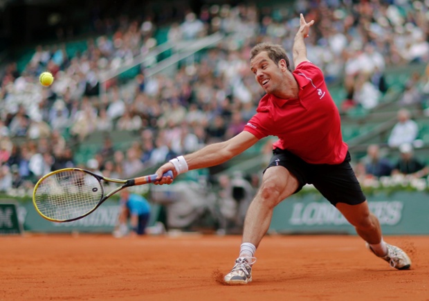 Richard Gasquet of France stretches out to hit a return to Carlos Berlocq of Argentina during their men's singles match at the French Open tennis tournament at the Roland Garros stadium in Paris, France.