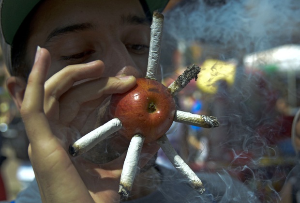 Medellin, Colombia: A man smokes marijuana joints on an apple during the World Day for the Legalization of Marijuana.