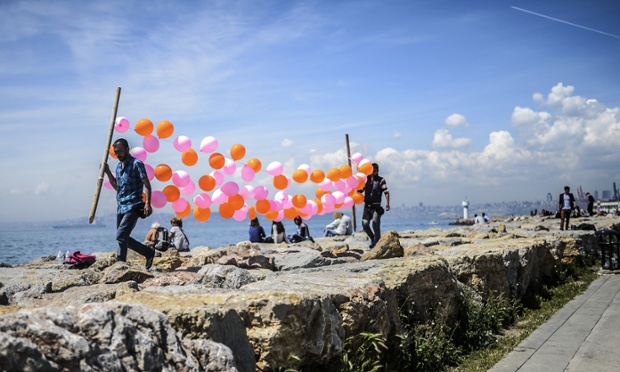 Istanbul, Turkey: Men carry balloons near the sea at Kadikoy.