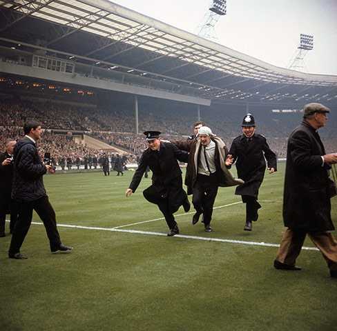 memory lane: A jubilant Liverpool fan is escorted off the pitch by policemen 