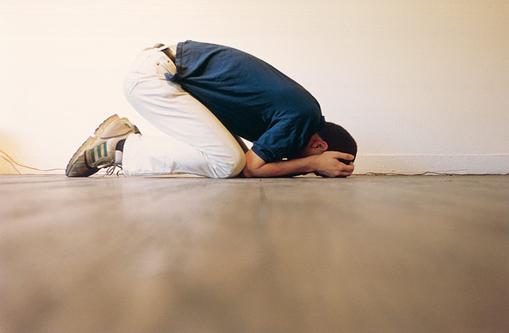 Wolfgang Tillmans: man crouched down on floor praying