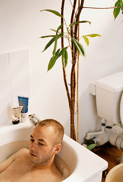 Wolfgang Tillmans: man in bath plant in background