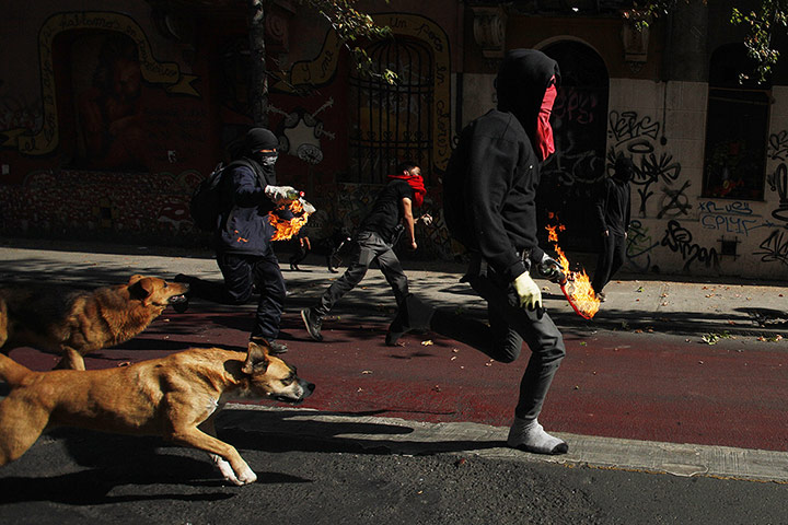 20 Photos: Protesters prepare to throw petrol bombs at police in Santiago, Chile