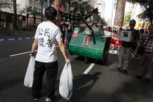 A protester stands in front of a mock tank to symbolise the 'tank man' to mark the 25th anniversary of China's bloody crackdown on Tiananmen Square.