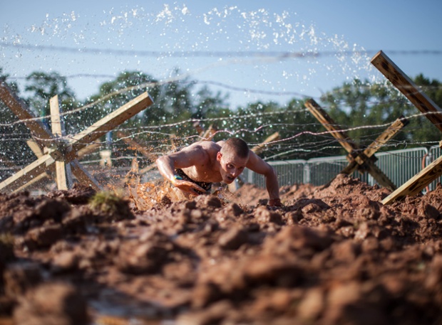 Georgia, USA: Runner Hobie Call crawls through the last obstacle at the inaugural Battlefrog Obstacle Course Race designed by Navy SEALs.