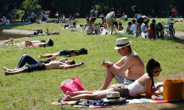 Tokyo, Japan: People lie and sunbathe at a park as temperatures go up high at 32 degrees Celsius.