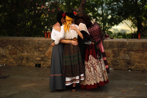 Ronda, Spain: Women wearing traditional costumes embrace during the Romantic Ronda.