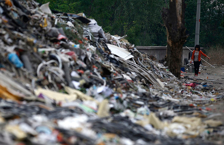 e-waste from the agencies: A woman walks near mounds of garbage