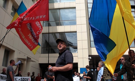 Ukrainian protesters hold banners outside the tax ministry in Kiev on 23 May 2014.