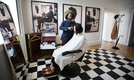 Hairdresser Johnnie Sapong works in a live barber shop at the 'Return of the Rudeboy' exhibition at London's Somerset House
