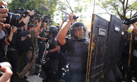 Media take pictures as military police clash with demonstrators (not pictured) near Caarao metro station during a protest against the 2014 World Cup, in Sao Paulo.