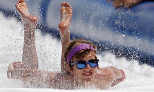 A festival-goer  cools herself as she goes down a water slide at the Bonnaroo Music and Arts Festival on Thursday, June 12, 2014, in Manchester, Tenn. (Photo by Wade Payne/Invision/AP)  plg