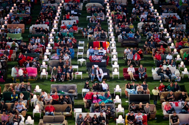 German soccer fans watch the opening game of the World Cup while sitting on sofas in the 1.FC Union stadium in Berlin, Thursday, June 12, 2014. (AP Photo/Axel Schmidt)  plg