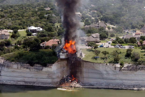 Holy Smoke. Building crews set fire to a luxury lake house left dangling 75 feet in the air as the cliff it was built on collapsed in Lake Whitney, Texas. 