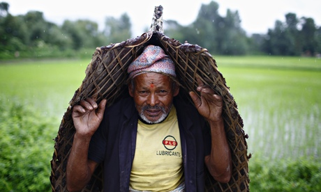 A farmer covers himself from the rain during Asar Pandra festival in Bhaktapur