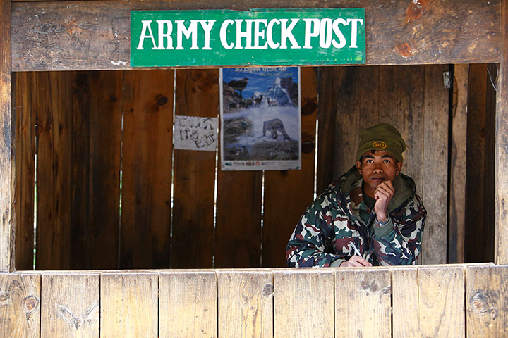 FTA: Ascent to Everest: A Nepalese army soldier sits in a check post as he waits to check permits f