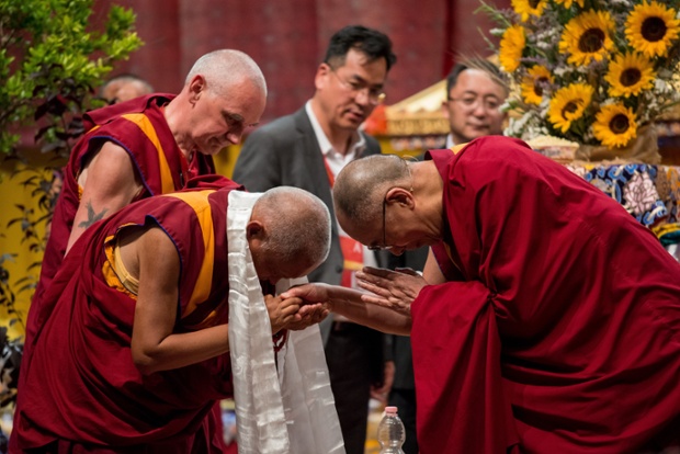 The Dalai Lama is greeted by a fellow monk before giving teachings on the 'Wisdom of Compassion' at Modigliani Forum, Livorno, Italy