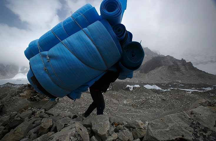 FTA: Ascent to Everest: A porter carries mattresses back from Everest base camp