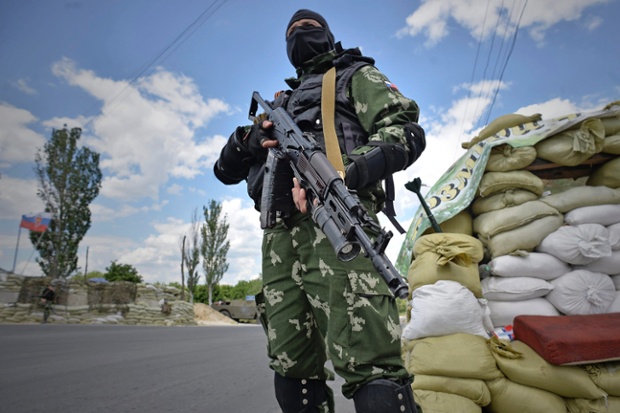 Pro-Russian militant stands at a checkpoint in the outskirts of Donetsk, Ukraine. Ukrainian President Petro Poroshenko called for fighting to stop by the end of the week, in comments after a meeting of security officials in Kiev.