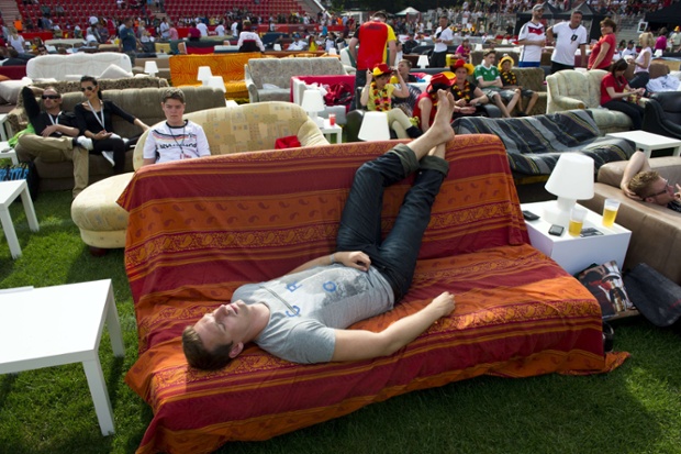 Sofa-surfing fan: A Germany supporter waits for the start of the FIFA World Cup 2014 group G football match Germany vs Portugal, at a public viewing in Berlin's Eisern Union stadium, at which supporters were invited to bring their own sofas to watch the match.