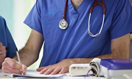 NHS doctor fills out paperwork