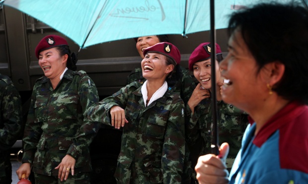 Thai soldiers and a woman, foreground, share a laugh during a 'Return Happiness to Thai People' at Bangkok's Victory Monument. Photograph: Apichart Weerawong/AP