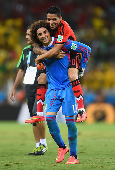 Brazil game:  Goalkeeper Guillermo Ochoa of Mexico celebrates with Javier Aquino